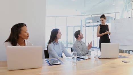 female executive giving presentation to her colleagues in conference room 4k