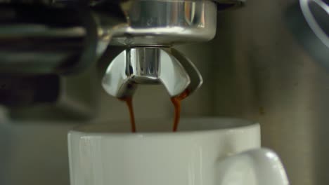 el líquido del café sale de un grifo de metal