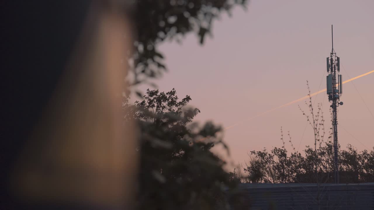 Rack Focus From Cellular Yellow Stick To Phone Cell Mast Tower. Follow Shot