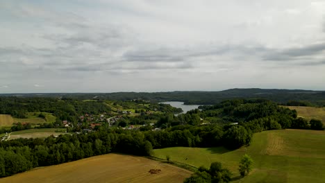 countryside farm fields and nature of small village borucino at daytime in poland - descend aerial shot