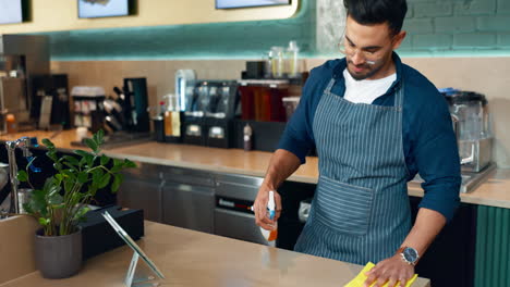 Waiter-man,-spray-and-cleaning-table-for-hygiene