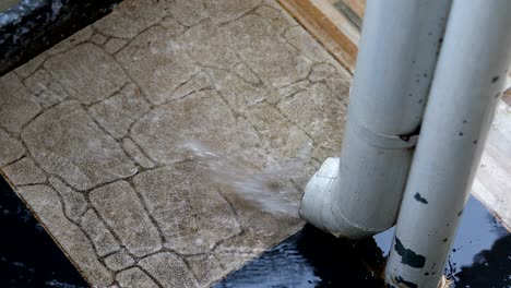 rain water flowing in tube pipe drain from gutter roof house