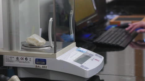 a woman putting a glove in a precision scale