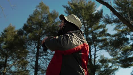 man out in nature taking photographs and looking with his binoculars