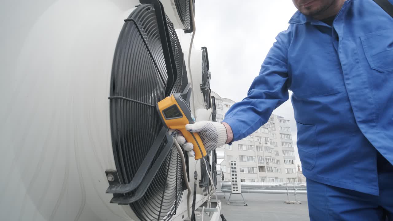 Technician uses a thermal imaging infrared thermometer to check the condensing unit heat exchanger