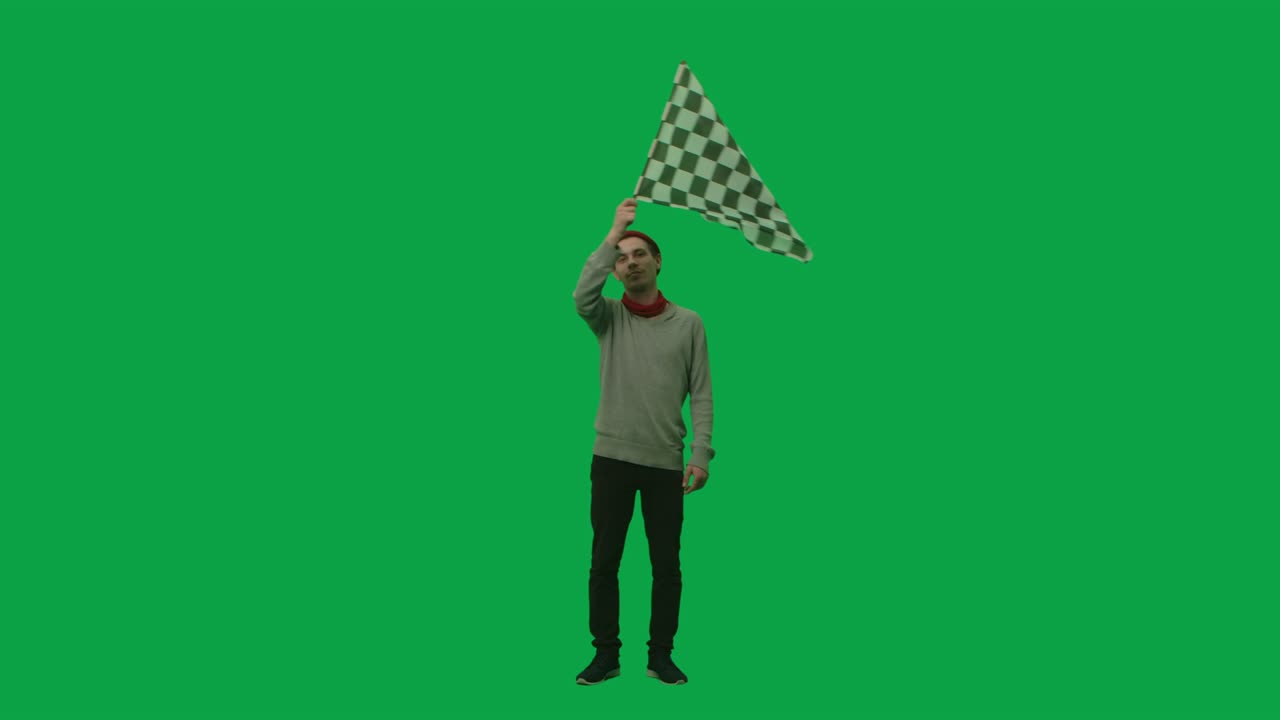 retrato de un joven con ropa elegante y sombrero agitando una bandera de carrera a cuadros en blanco y negro. longitud completa en fondo de pantalla verde. cámara lenta lista, 4k a 59,94 fps