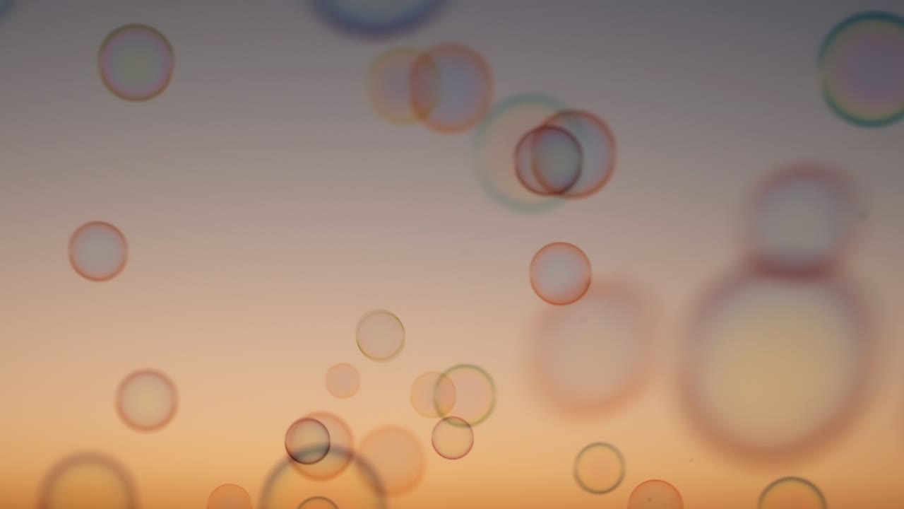 Soap bubbles on sky at sunset summer slow motion. Bright background multicolored bubbles smoothly fly in sky. Childhood, Freedom. Dreams. Relax. Happiness