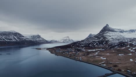 Breathtaking-aerial-view-over-winter-landscape-in-the-arctic-sea-and-beautiful-snowy-mountains-in-Westfjords-of-Iceland,-Sudavik