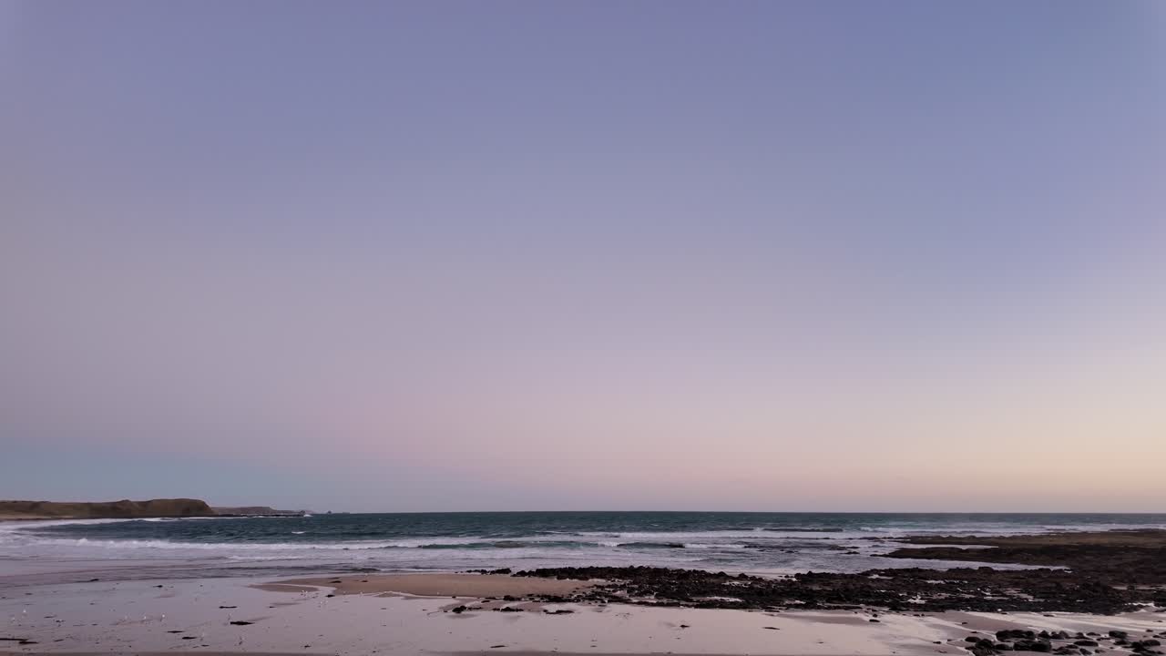 Panning footage of the penguin parade beach in the evening.