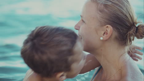 Boy-kissing-mother-while-bathing-in-the-sea