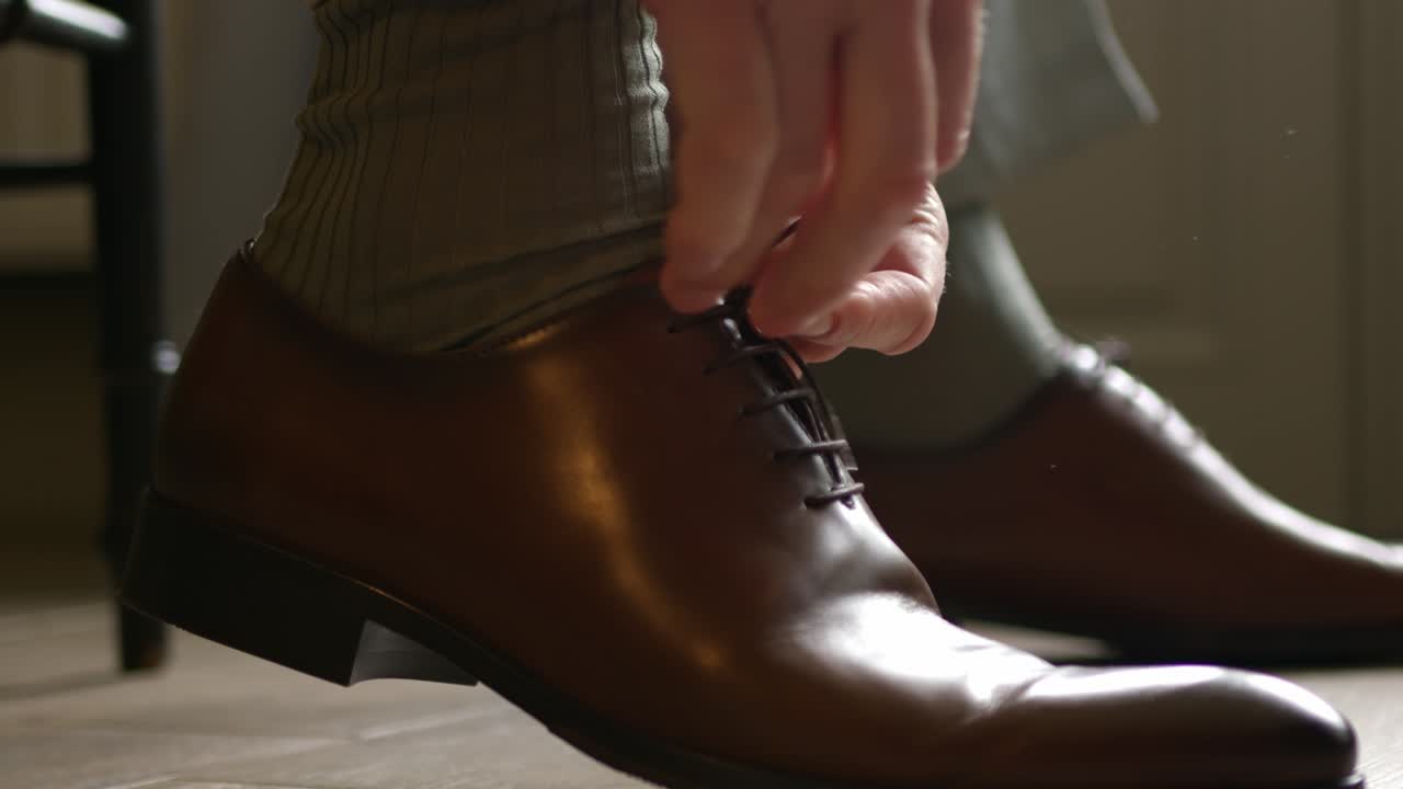 Cropped Hands Of A Man Tying The Lace Of A Classic Brown Shoe Leather. Close-up Shot