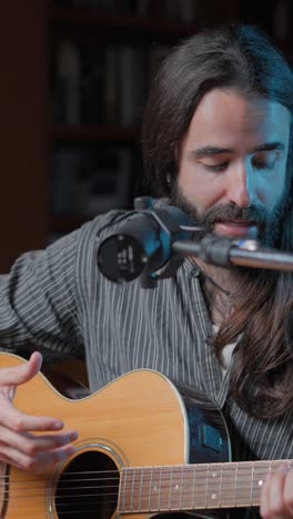 musician performing with acoustic guitar and microphone