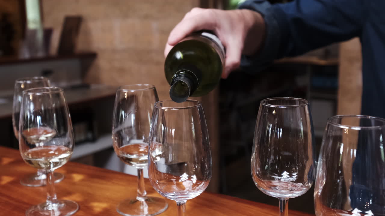Versare vino bianco nei bicchieri al bancone del bar.