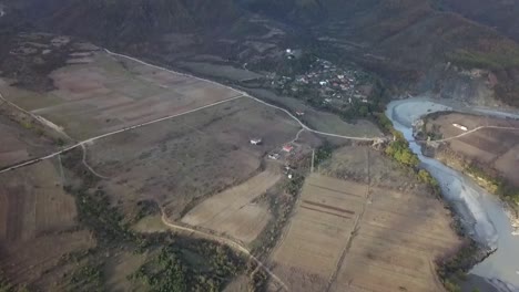 Vjose-River-running-next-to-farmland-in-Southern-Part-of-Albania-in-front-of-the-beautiful-mountain-range