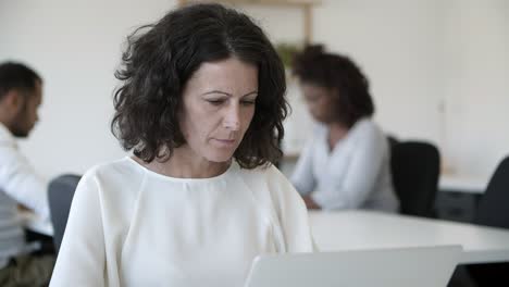 Thoughtful-mature-programmer-working-with-laptop