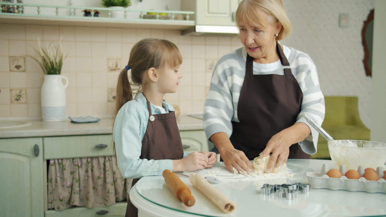 할머니와 손녀가 쿠키를 고 있습니다.