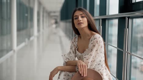 hermosa joven en una plataforma felizmente se quita el sombrero y posa frente a la cámara