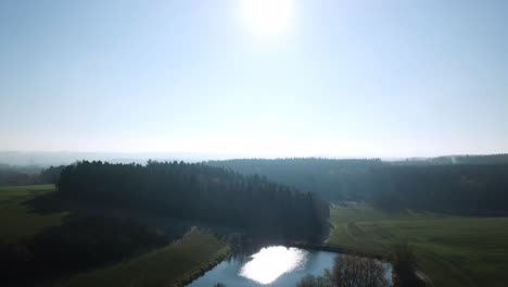 Luftaufstieg-über-Wald-Und-See-In-Der-Morgensonne