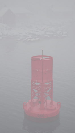 a red buoy in foggy water