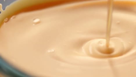 close-up of melted chocolate sauce being poured into a bowl