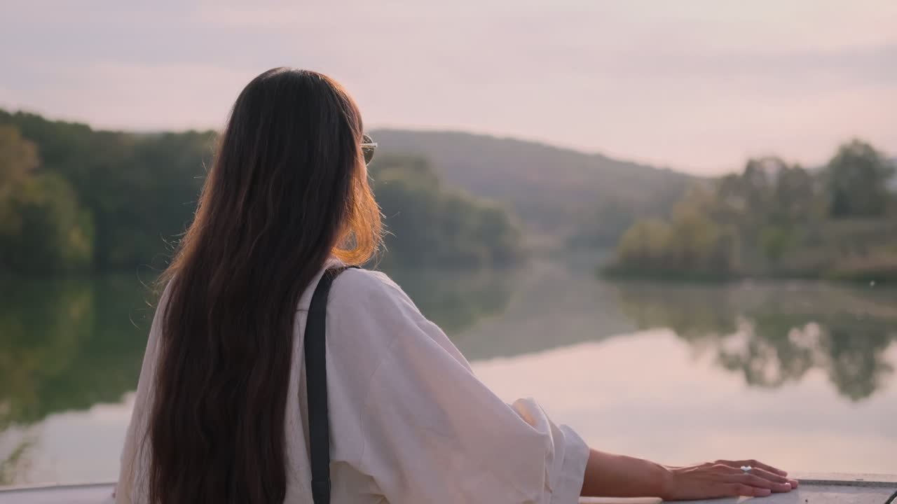 해가 지면 호수를 바라보는 여자