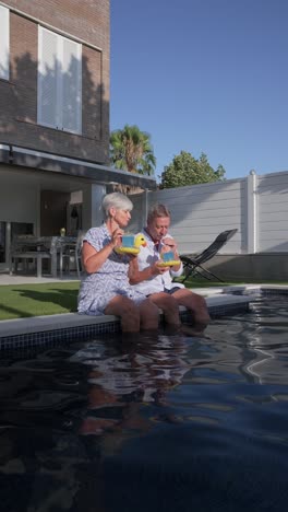 senior couple enjoying drinks by the pool