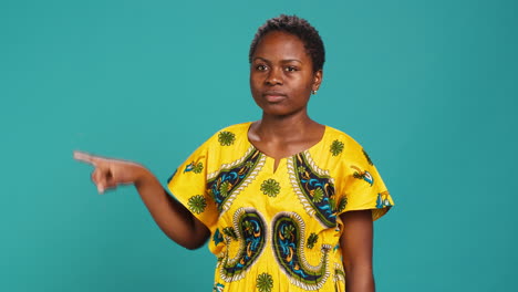 Young-woman-indicating-direction-to-left-or-right-in-studio