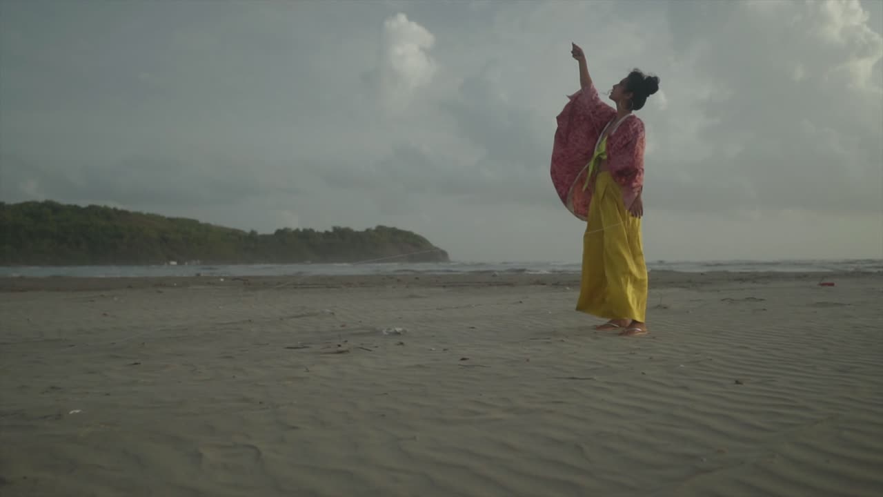 매혹적인 전망은 활기찬 노란색 앙상블로 장식된 바다와 가까운 곳에서  ⁇ 을 즐겁게 날리는 모델의 평화로운 본질을 포착합니다.