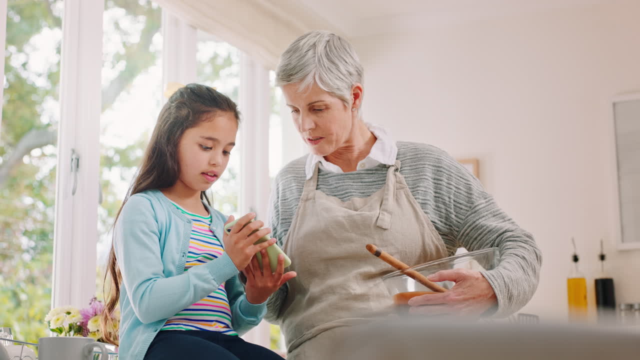 teléfono, niña y abuela cocinando en la cocina