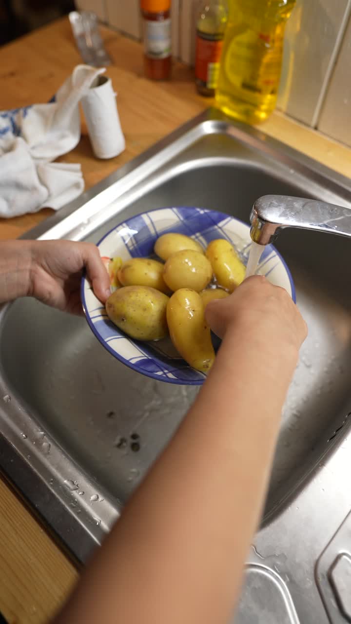 lavando patatas en el fregadero de la cocina