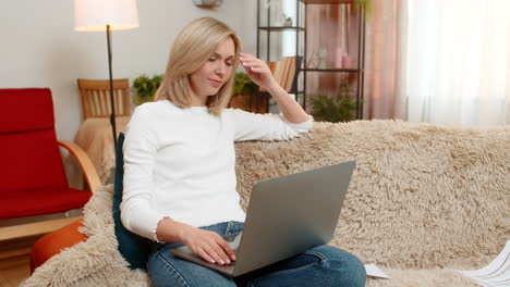 adult woman frustrated with laptop work at home throwing papers waving hand in irritation stress