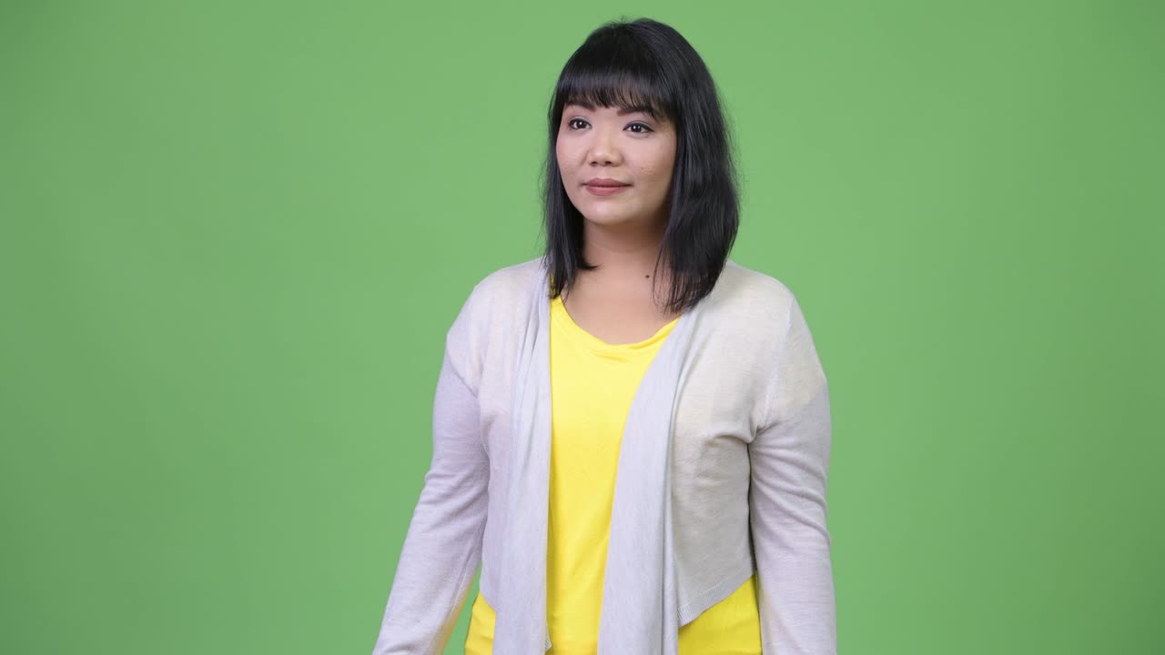 Beautiful happy Asian woman smiling while giving thumbs up