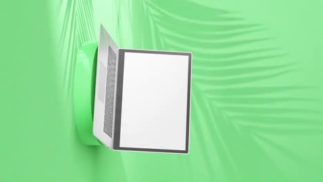 portátil plateado elegante en un pedestal redondo, pantalla vacía con sombras de palma en un fondo verde lima, vertical