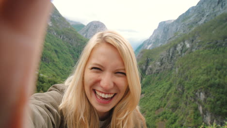 happy woman taking selfie in norwegian fjord