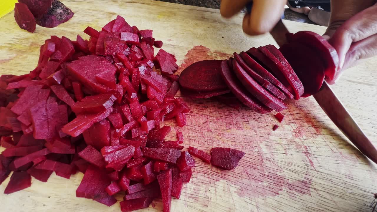 Close up of female hands in gloves cutting beet on kitchen board