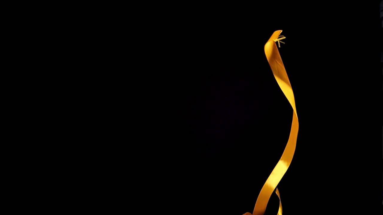 toma estática en cámara lenta de cinta de regalo que cae en rojo y amarillo para tomas estéticas y de lujo