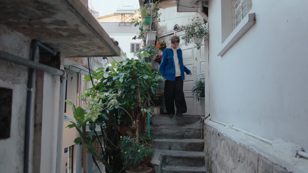 Woman Leaving House and Walking Away along the Street