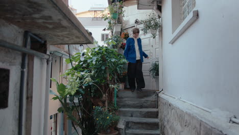 woman leaving house and walking away along the street