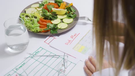 dietitian preparing healthy vegetable salad and diet plan.