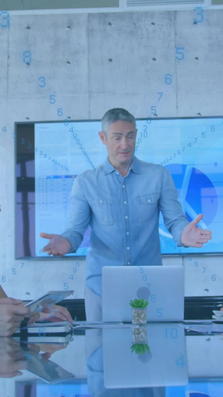 Animation of rows of changing numbers over caucasian senior man giving a presentation at office
