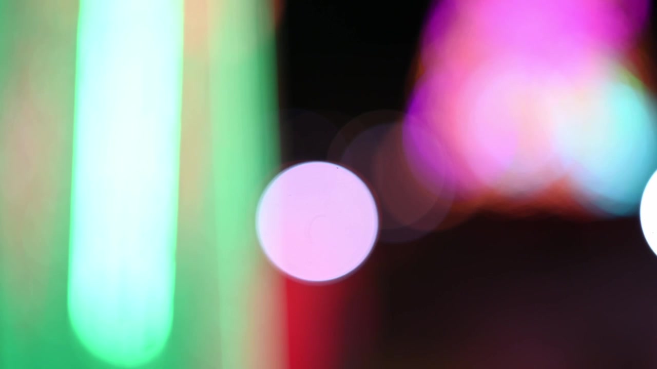 Vibrant Bokeh Lights and Green Streaks on a Dark Background