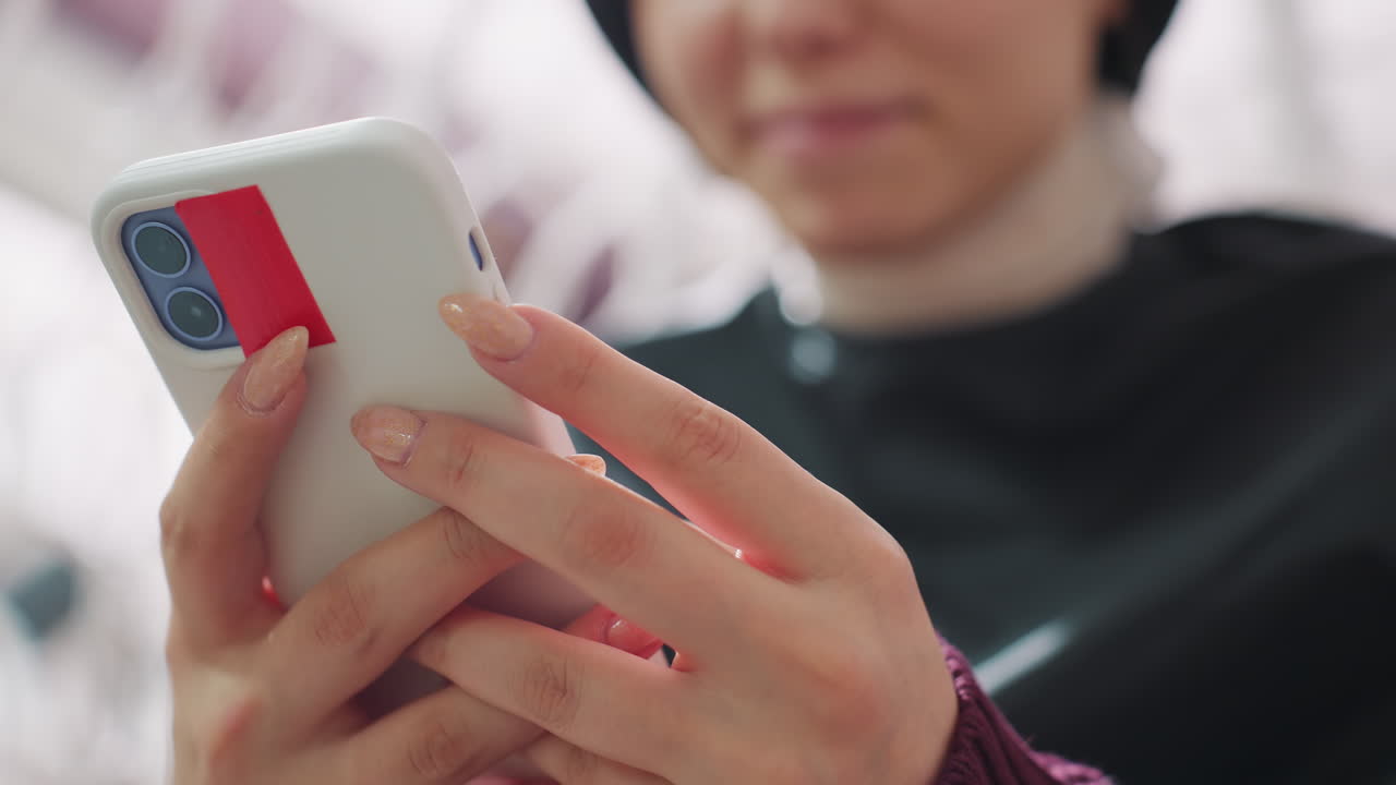 모바일 거래 과정을 클로즈업한 이미지입니다. 결제 중인 휴대폰 화면과 손가락에 초점을 맞췄으며, 실내에서 전자 결제를 완료하기 위해 휴대폰 화면을 탭하는 손가락을 상세하게 촬영했습니다.