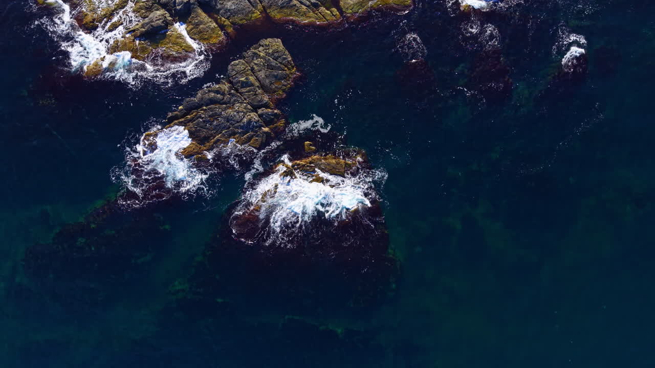 Majestic ocean waves crashing against rugged rocks in a tranquil seascape at sunset, capturing nature's beauty and serenity