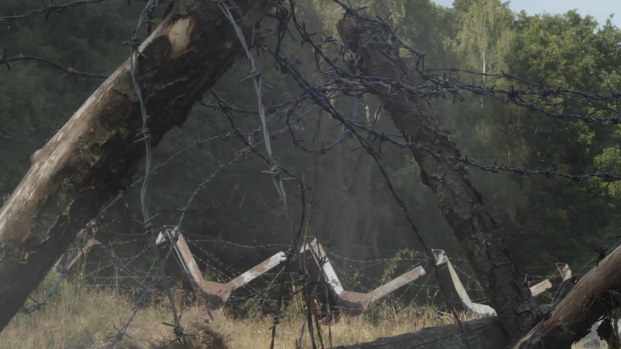 frontera abandonada con alambre de púas y barricadas envueltas en humo