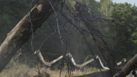 frontera abandonada con alambre de púas y barricadas envueltas en humo