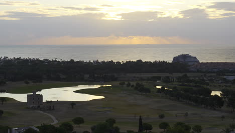 Time-lapse-captures-urban-seaside-landscape-during-sun-rise-over-the-sea-as-clouds-rush-by