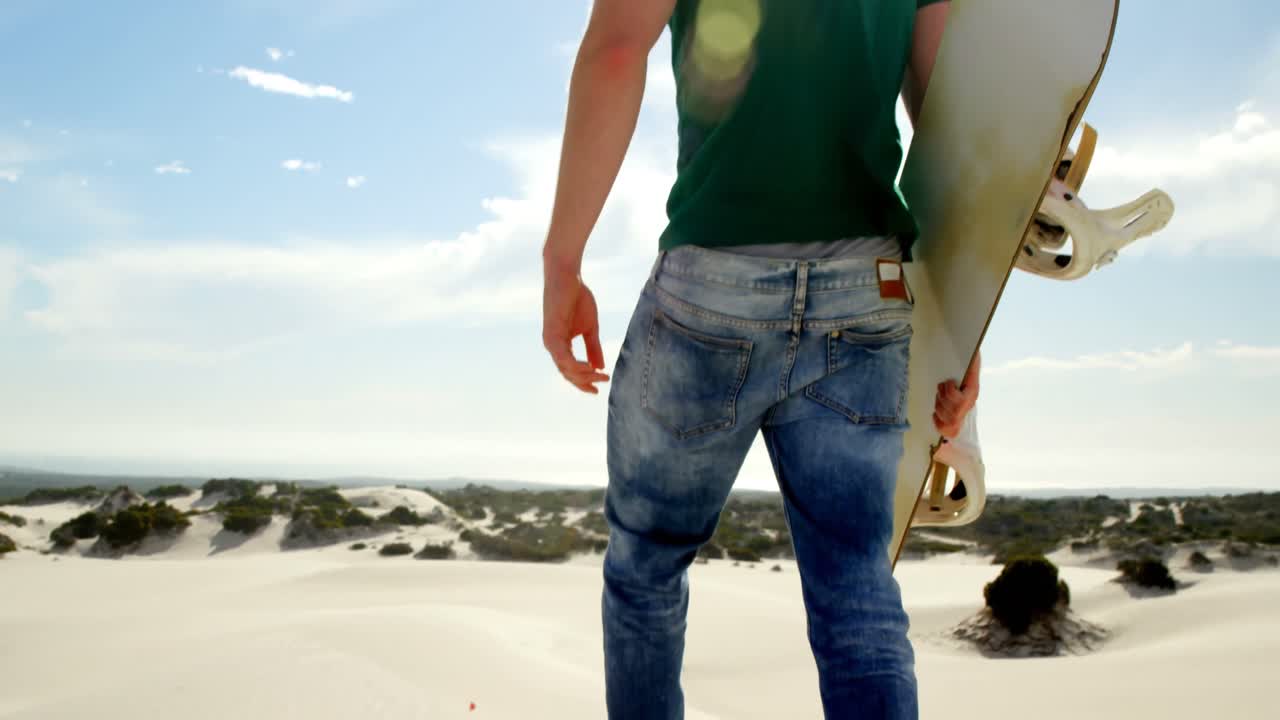 Man walking with sand board in the desert 4k