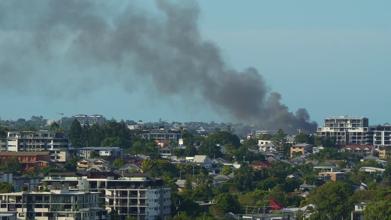A massive structure fire engulfs a commercial premises in Kedron, with a thick column of smoke billowing into the air, visible from Bowen Hills.