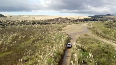 Camión-4wd-Conduciendo-A-Lo-Largo-Del-Arroyo-Te-Paki-Por-Grandes-Dunas-De-Arena-Cerca-Del-Cabo-Reinga-En-Nueva-Zelanda