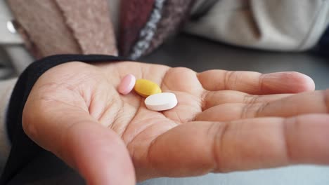 person holding various colored pills